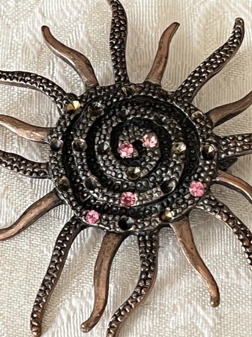 Broche vintage en métal bronze forme soleil ou astre spirale strass roses